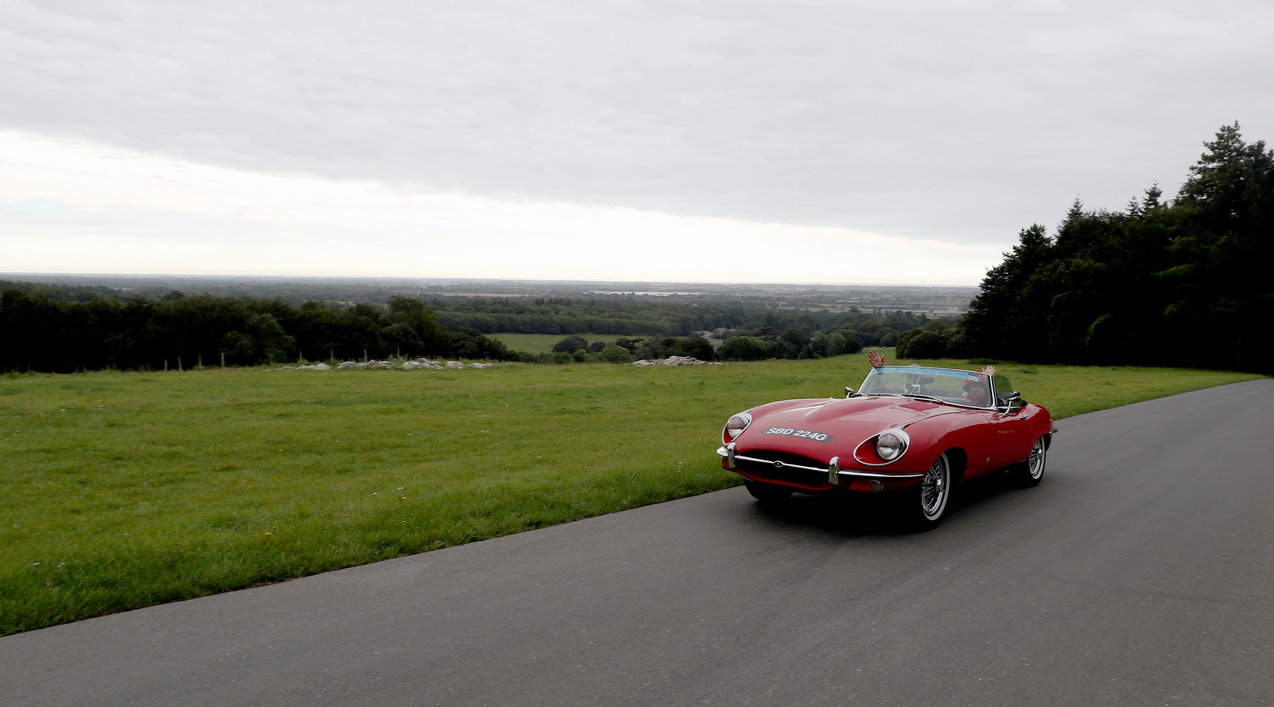 Red classic jaguar on a countryside drive