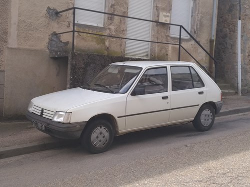 White Peugeot 205 parked on the side of a road