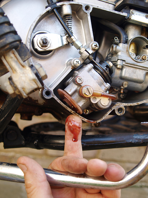 Hand pointing to oil leak