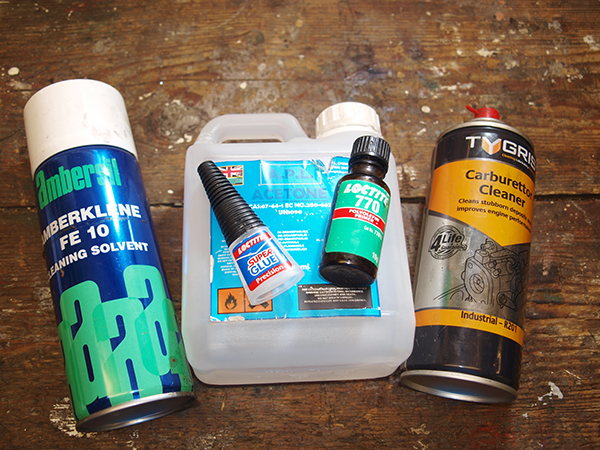 Cleaning solvent, acetone, carburetto cleaner, super glue on table