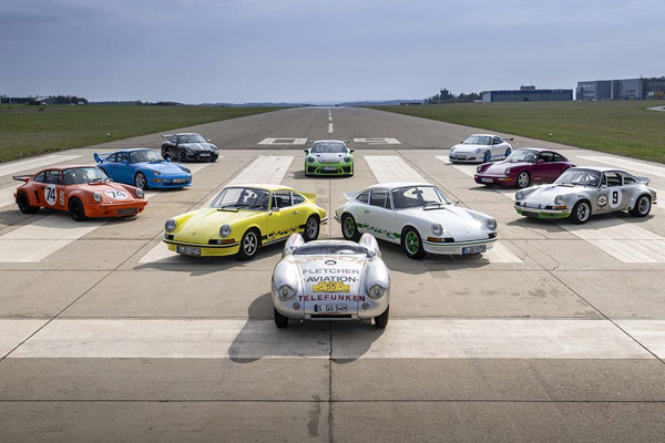 10 variously coloured Porsche 911 Carrera 7 7 RS's, parked in a formation on a runway