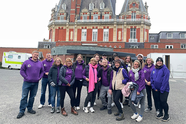 18 Of The Footman James Office In Purple Logoed Hoodies With Chateau Impney In The Background