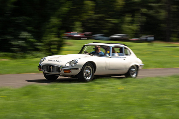 cream-e-type-jag-driving-along-grass-a-verge