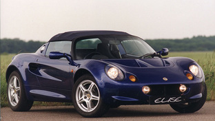 dark-blue-lotus-elise-with-grass-tree-and-sky-backdrop
