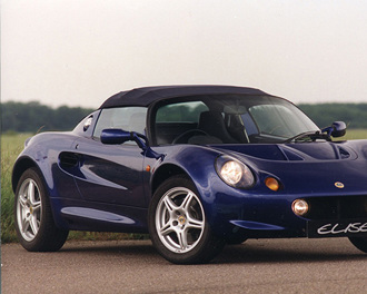 dark-blue-lotus-elise-with-grass-tree-and-sky-backdrop