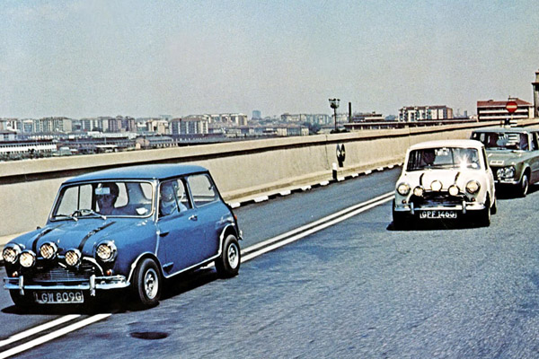 Blue And A White 1969 Mini Cooper And Italian Police Alfa Romeo Giulia on a bridge in Turin in the film the Italian job