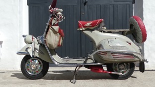 An accessorised 1953 Vespa standing in the sun