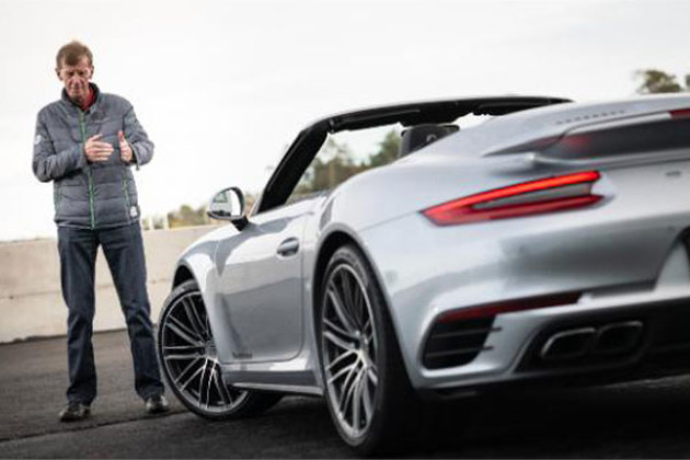 walter-rohrl-standing-next-to-a-silver-por