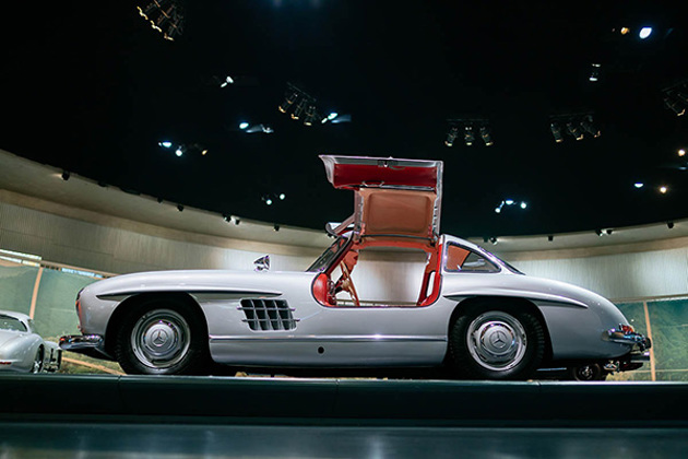 silver-mercedes-benz-300sl-gullwings-on-a-platform-in-a-showroom