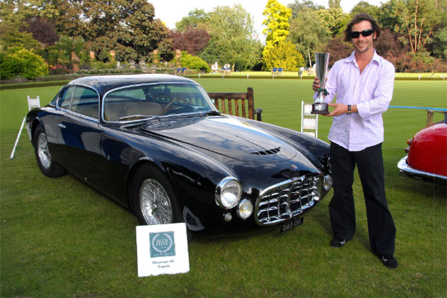 jay-kay-holding-trophy-next-to-black-1954-1957-maserati-a6g