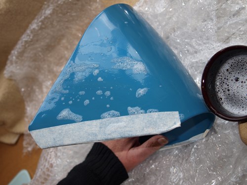 Man holding petrol cap covered in soapy water