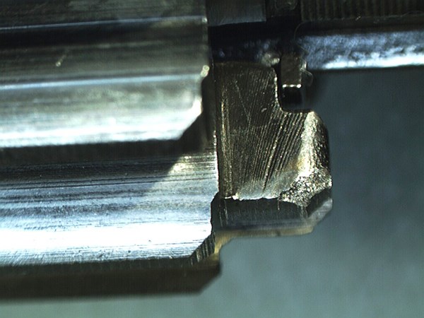 The striations, or machining marks, to the left of the damaged area show what the dog’s face should have looked like