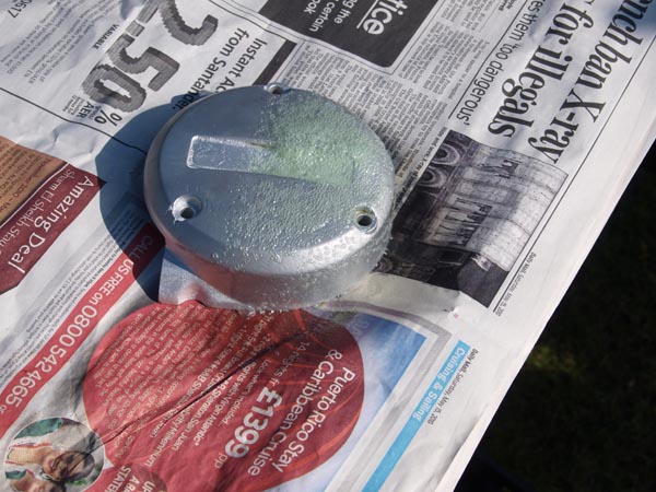 Alloy with gelled aerosol stripper sitting on newspaper