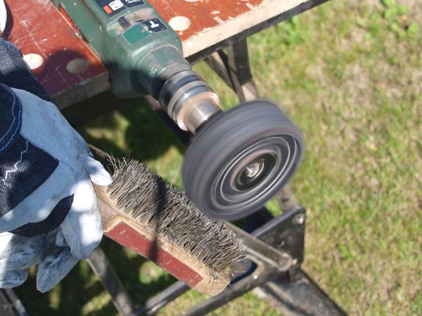 Man using wire brush to clean mop