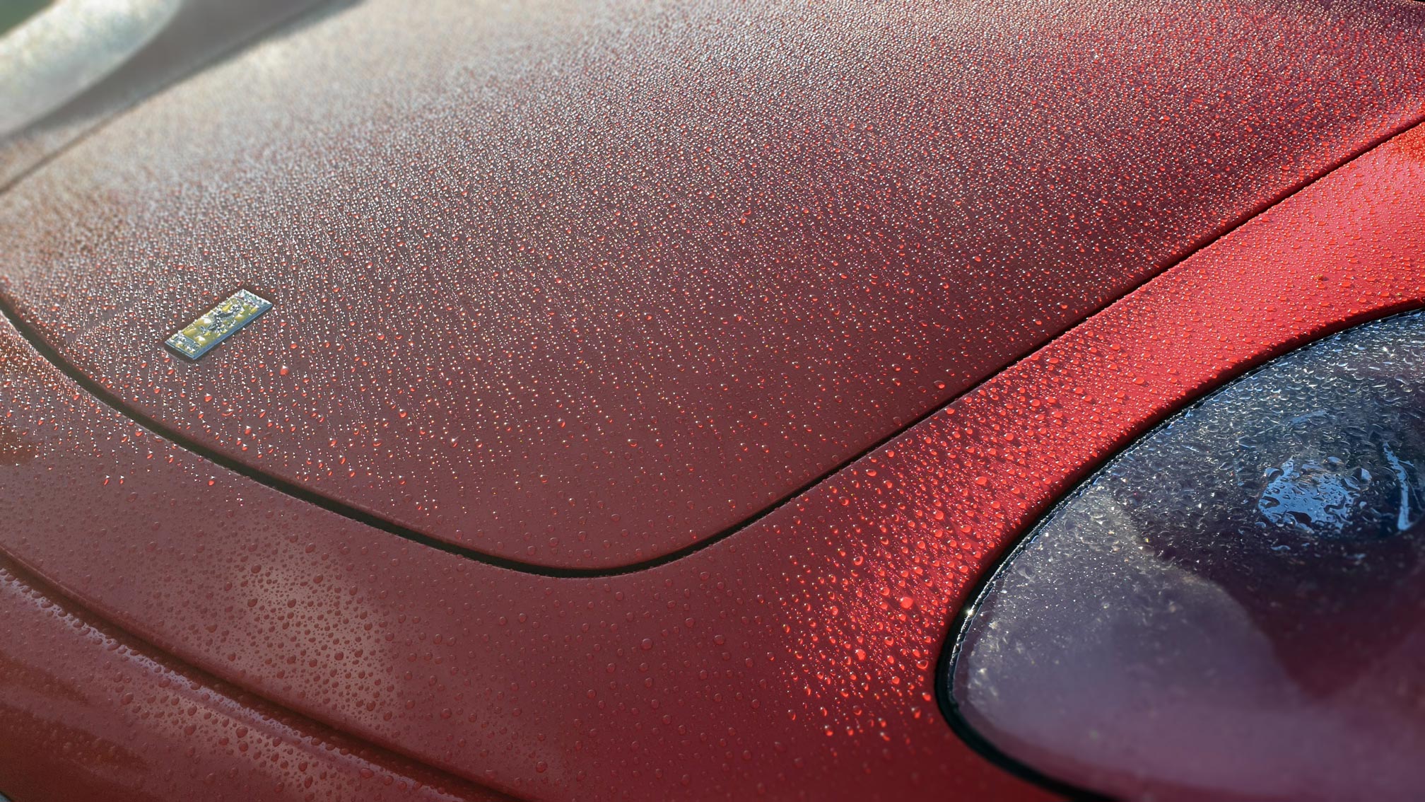 Red Ferrari hood with raindrops