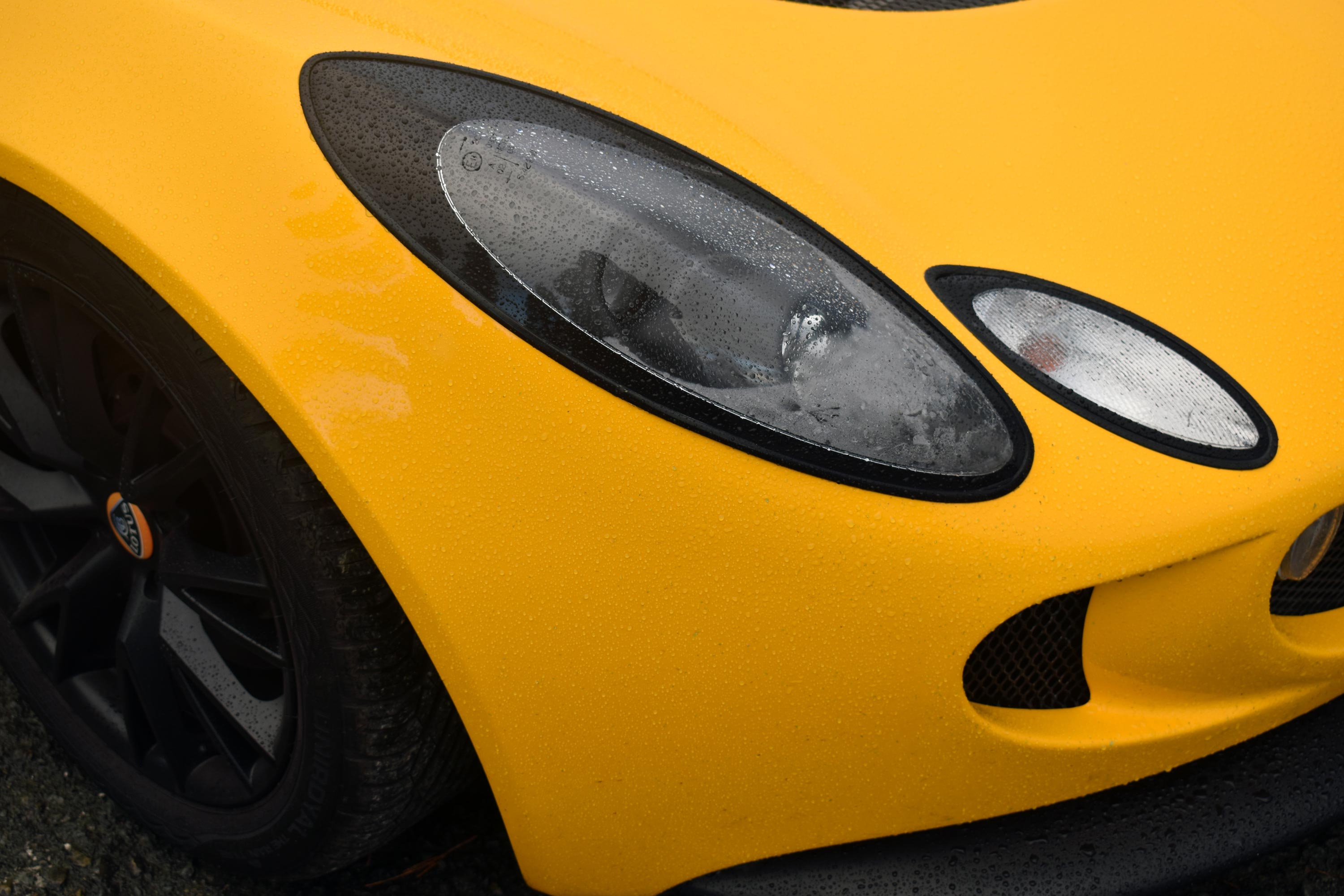 Yellow car hood with headlights and black rims