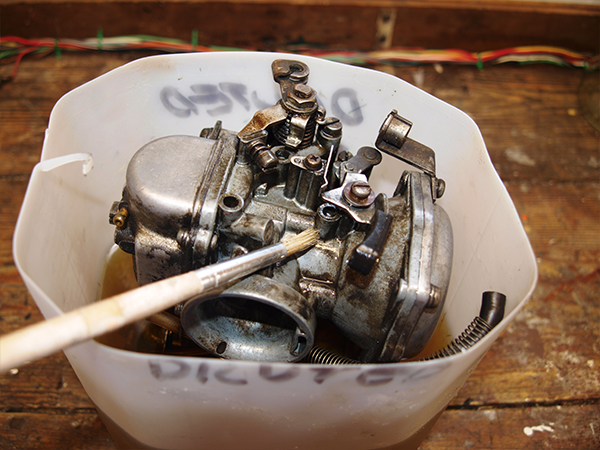 Washing Mikuni-Solex carbs in bucket with a brush