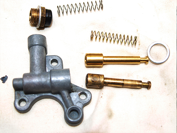 Choke plunger and parts on white cloth