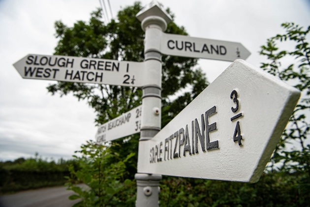Black and white road sign on a country lane