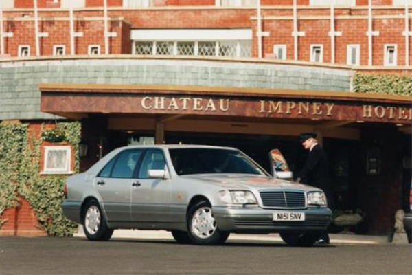 Silver 1991 to 1999 Mercedes S Class W140 outside the entrance of the Chateau Impney Hotel