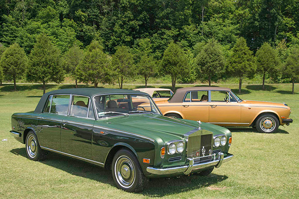 A Dark Green 1977 Rolls Royce Silver Shadow 1 and two 1979 Honey Gold coloured with Everflex roofs and trees in background