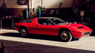 A red Maserati Bora in a workshop