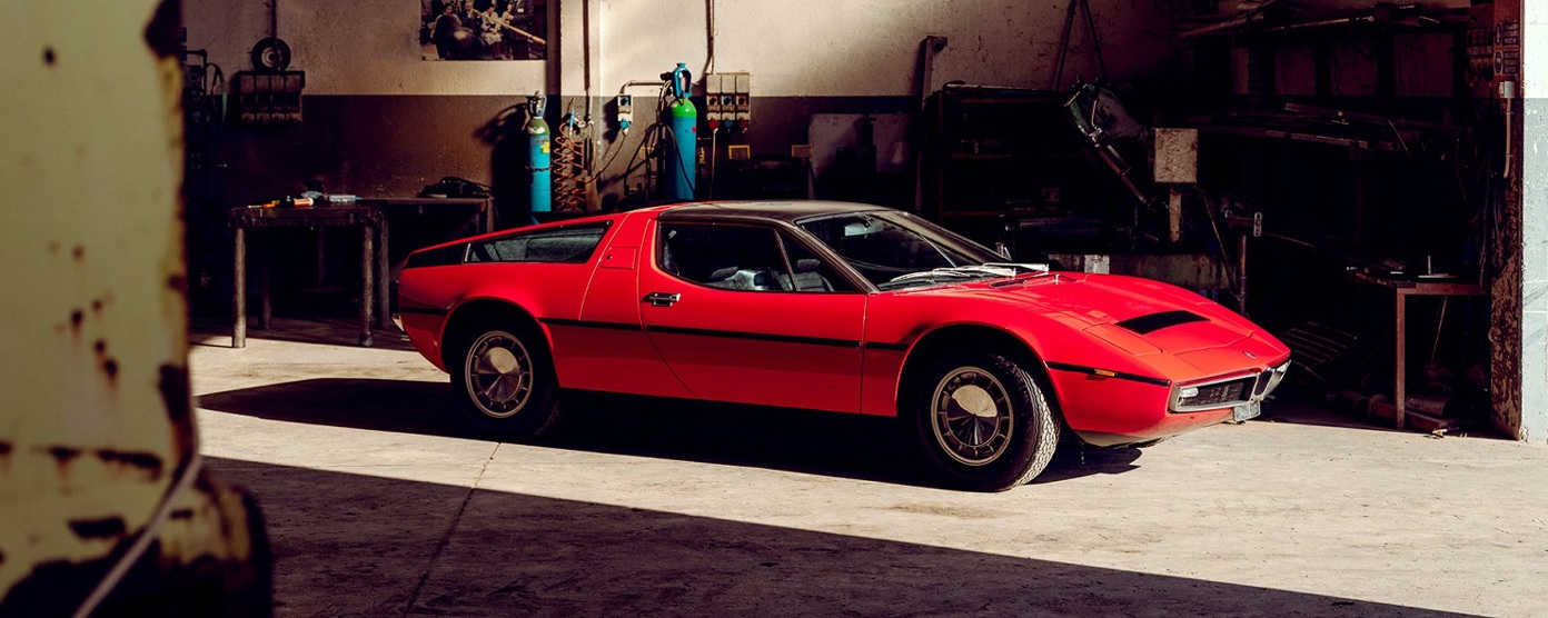 A red Maserati Bora in a workshop