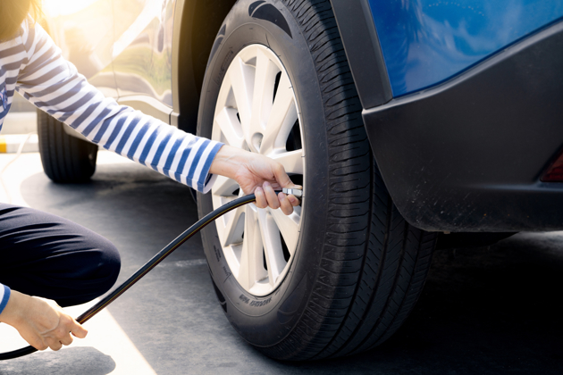 A close up of a woman's arm checking the tyre pressure