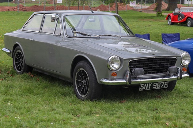 A grey Gilbern Genie at a car show