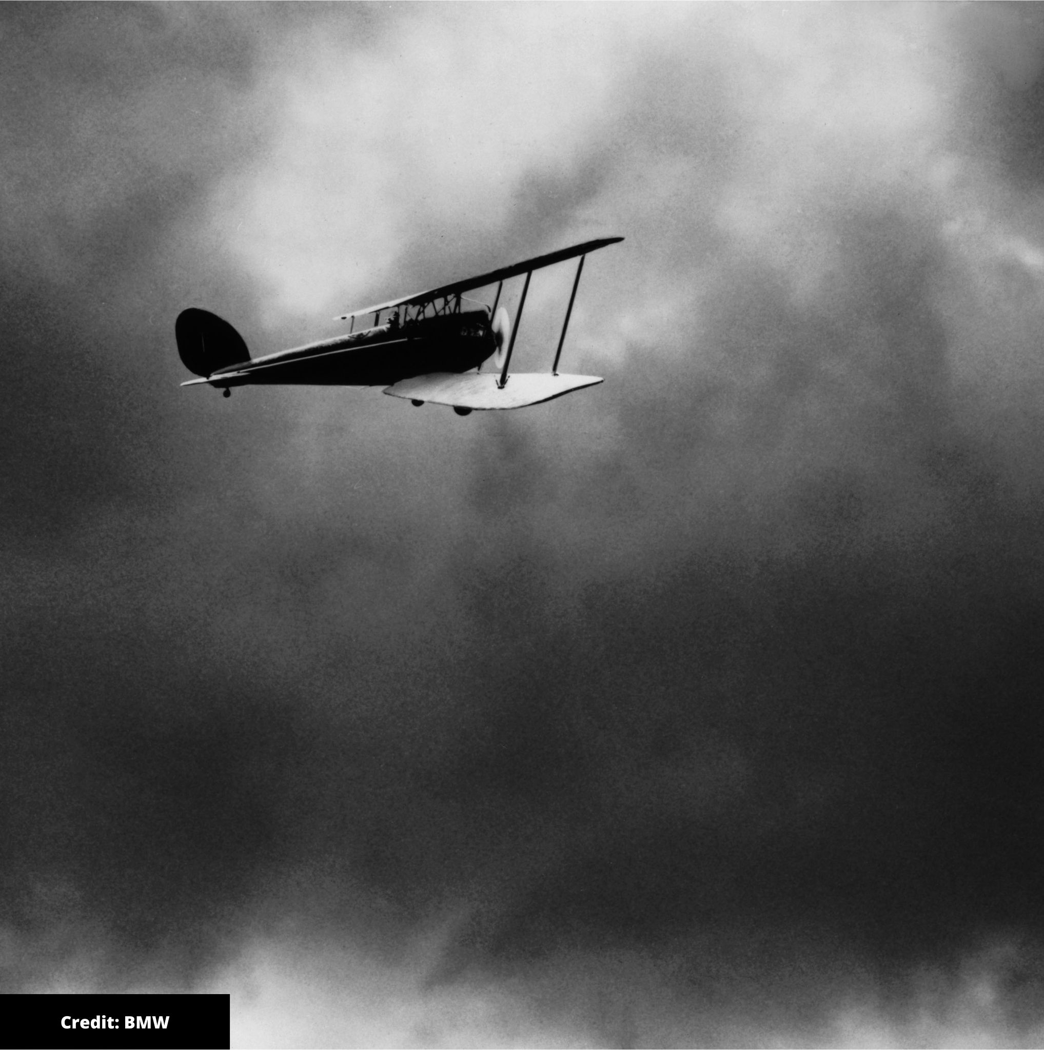 Black and white image of aeroplane flying through the clouds