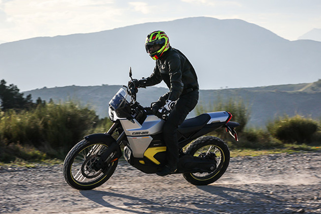 2025-can-am-origin-rider-standing-mountain-backdrop