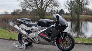 Aprilia RSV 1000 Mille parked in front of a lake