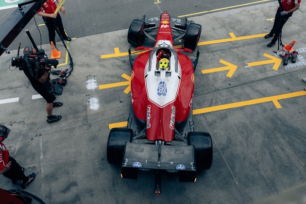 An aerial view of Lewis Hamilton sitting in a red F1 car