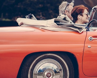 A couple in a red open top car