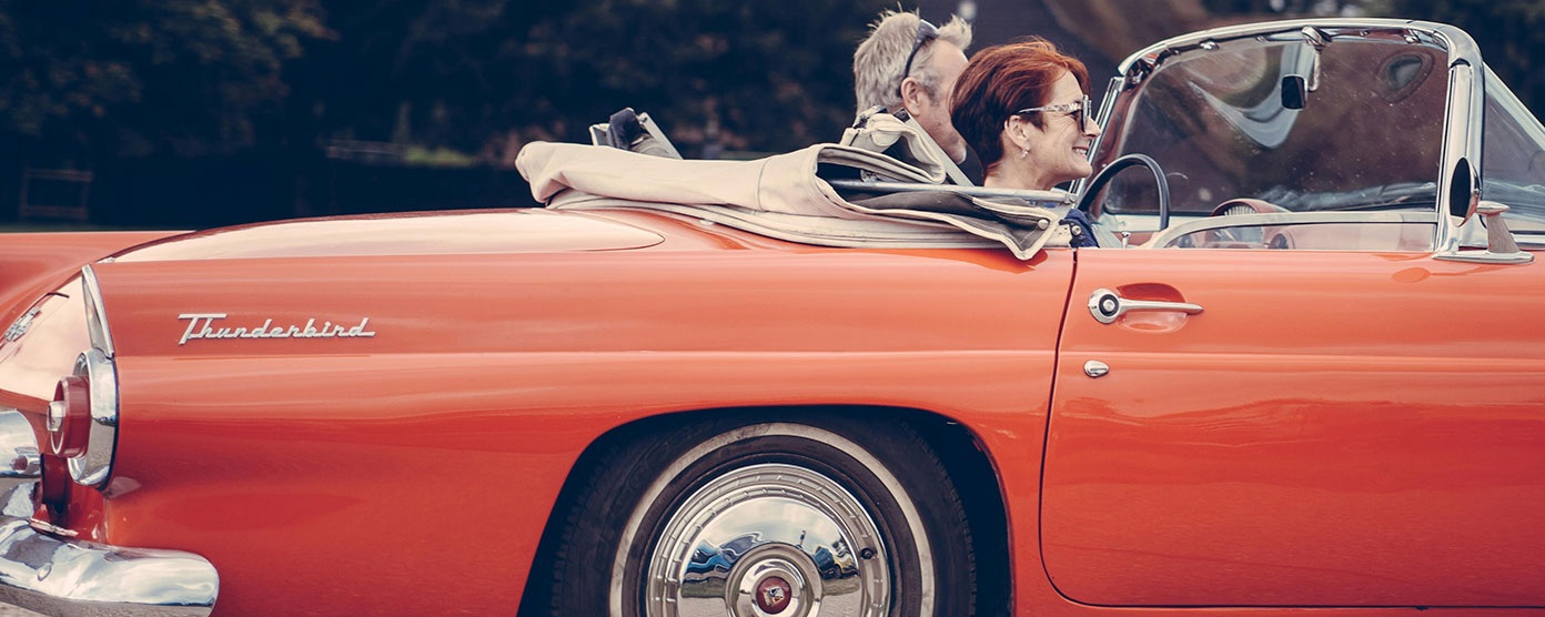 A couple in a red open top car