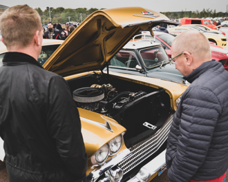 Men admiring a classic car at a show