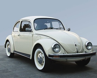 A cream VW Beetle against a blue background
