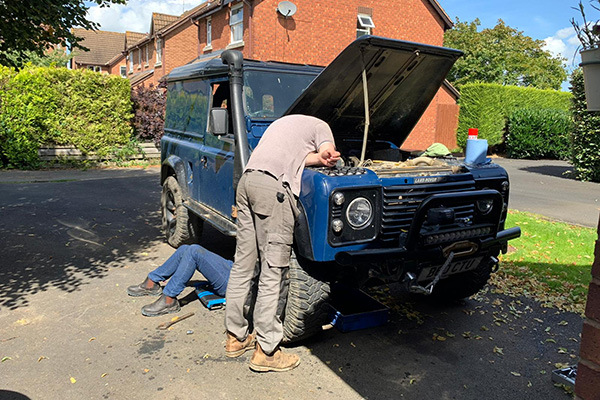 Two men working on a classic defender 90 landrover