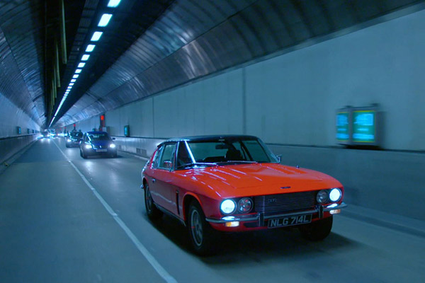 Red 1973 Jensen Interceptor Series IIII driving though a tunnel Courtesy The Classic Car Show