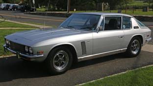 A silver 1971 Jensen Interceptor parked on a driveway