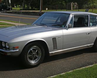 A silver 1971 Jensen Interceptor parked on a driveway