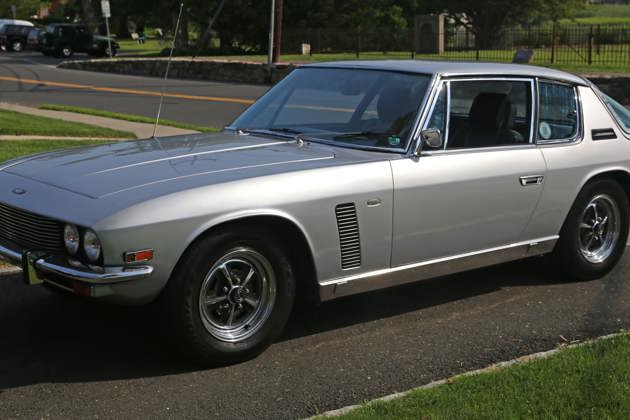 A silver 1971 Jensen Interceptor parked on a driveway