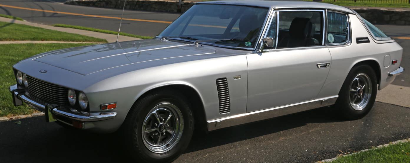 A silver 1971 Jensen Interceptor parked on a driveway