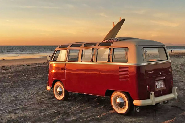 Red White 1950S Vw Transporter Type 2 On A Sandy Beach With A Surfboard