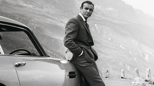 James Bond leans against a car in Goldfinger