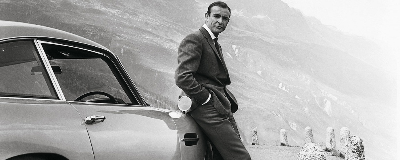 James Bond leans against a car in Goldfinger