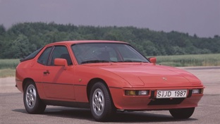 A red Porsche 924 parked on a race track
