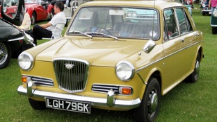 A mustard Wolseley at a classic car show