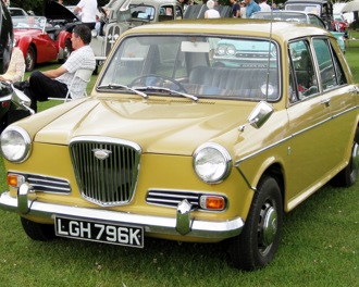 A mustard Wolseley at a classic car show