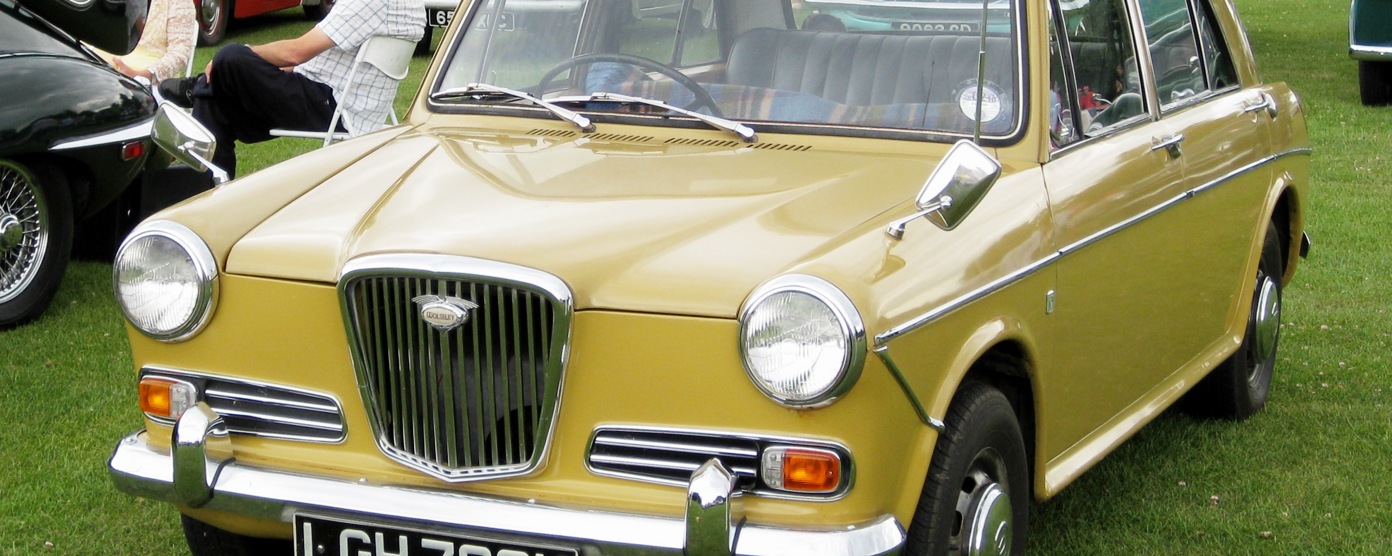 A mustard Wolseley at a classic car show